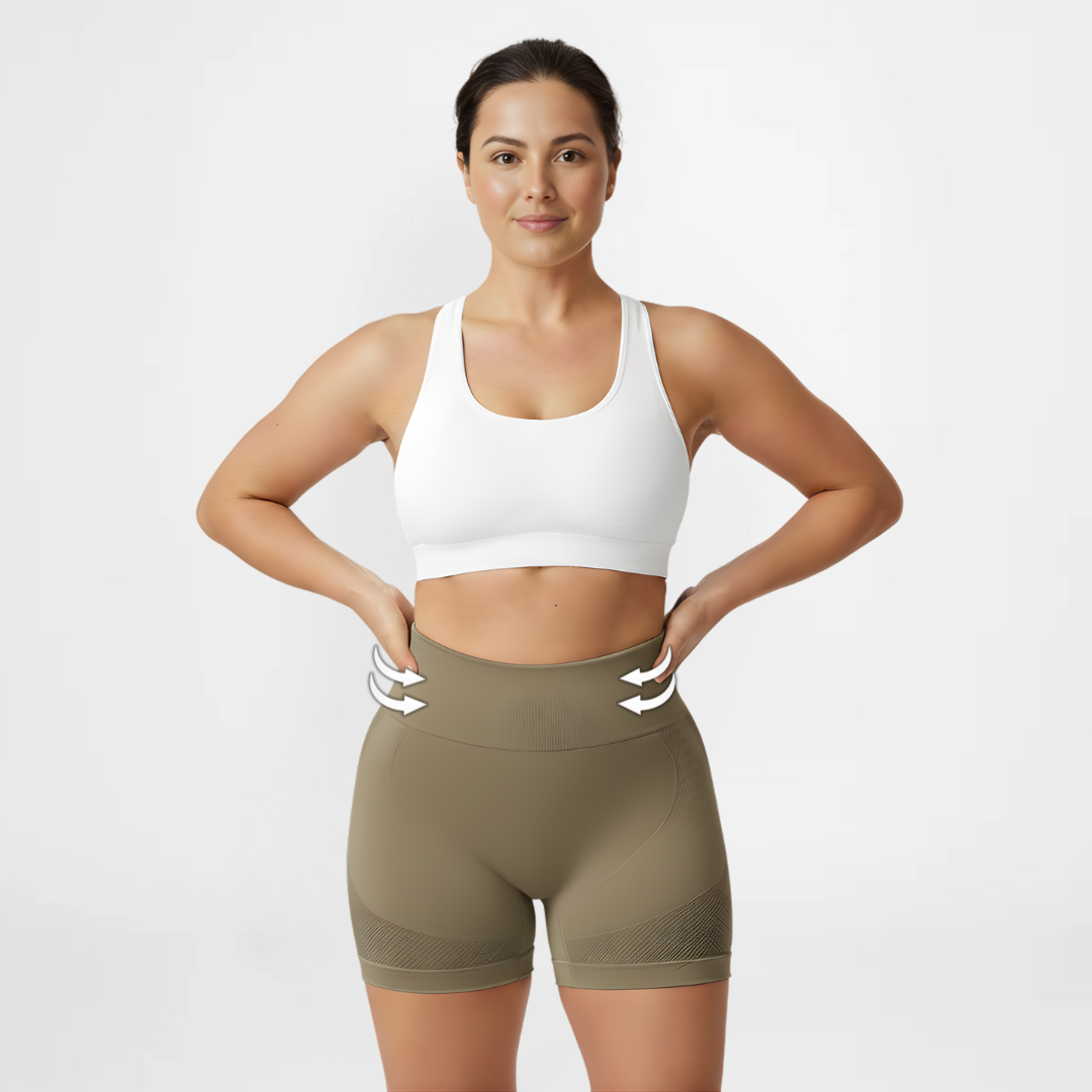 Woman wearing a white sports bra and olive green shorts on a light gray background